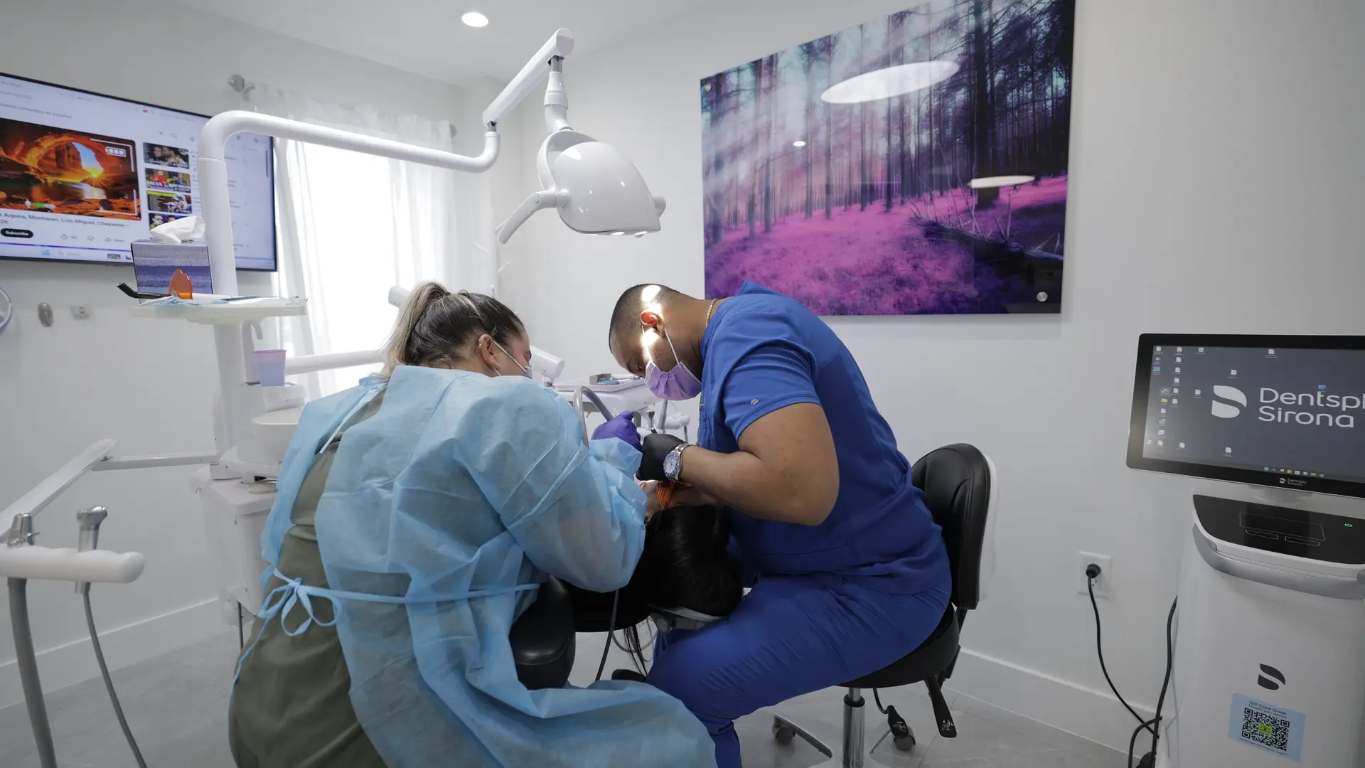 Two dental professionals working together to treat a patient.